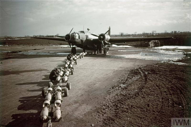 a ww2 bomber being loaded with bombs