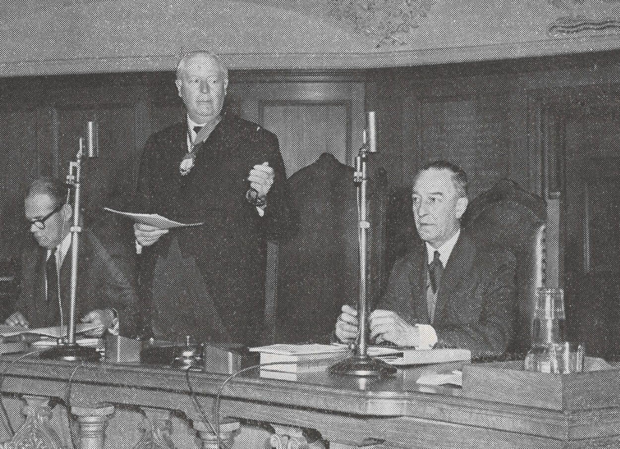 black and white photograph of middle aged man giving a speech