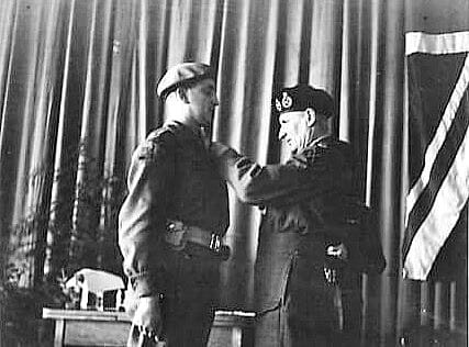 A world war two soldier having a medal pined on him by a senior officer