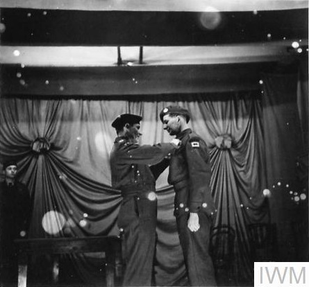 A World War Two soldier has a medal pinned on his chest by a senior officer