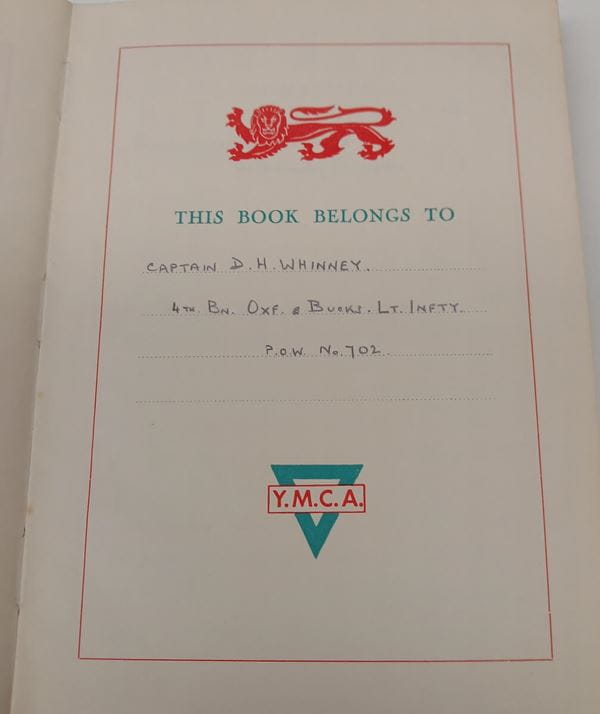 Photograph of a notebook frontispiece  This book belongs to Captain D.H Whinney 4th Battalion Oxfordshire & Buckinghamshire Light Infantry, P.O.W no, 702 written in