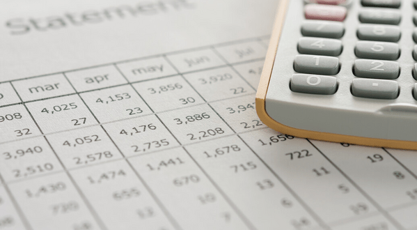 An electronic calculator sitting on top of printed financial statements