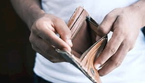 A person holding open an empty wallet