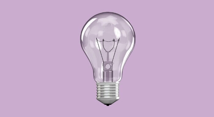 Silver light bulb on a purple background