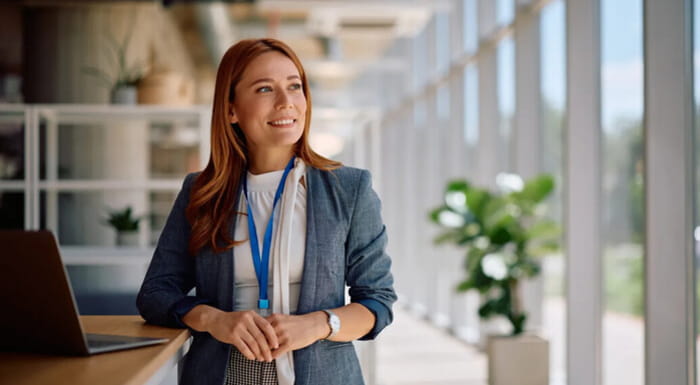 Woman in a suit walking, staring out the window