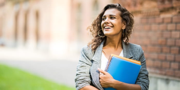 Young woman in grey blazer holding folders