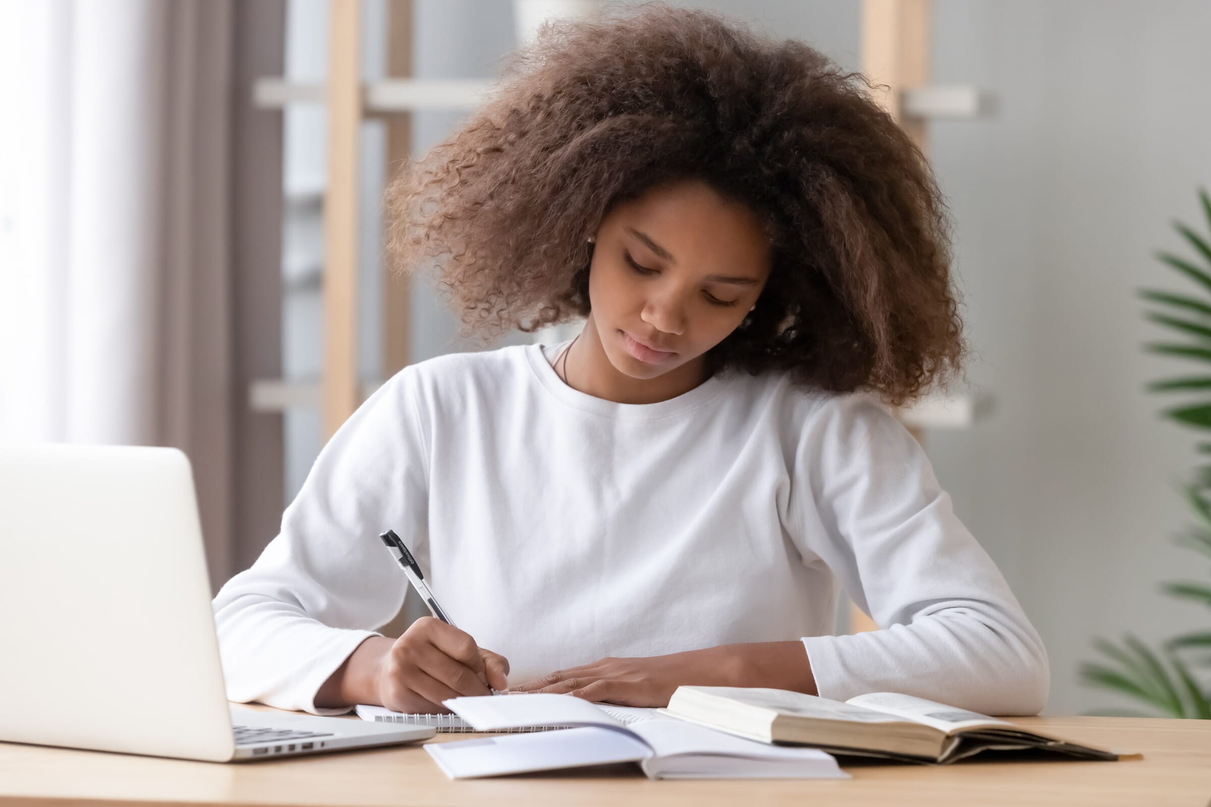 Student studying with laptop and books