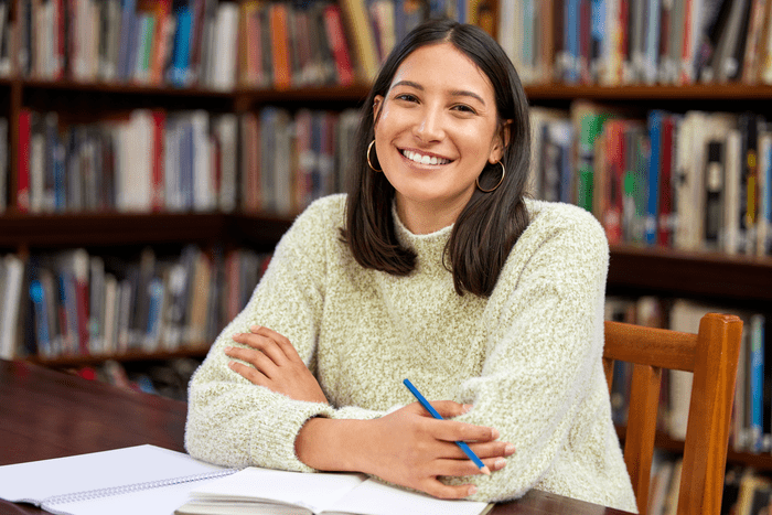 Girl with brown hair smiling in library