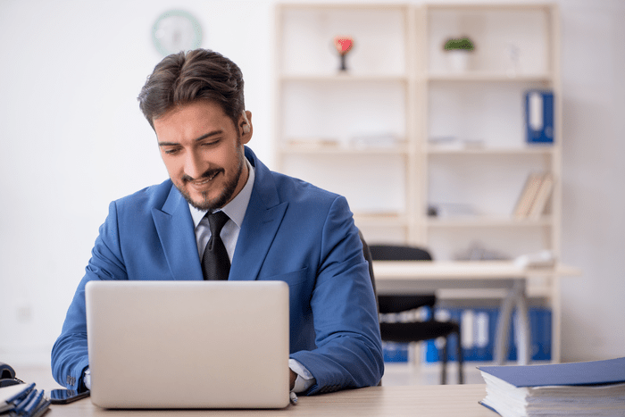 A young man sat at a laptop