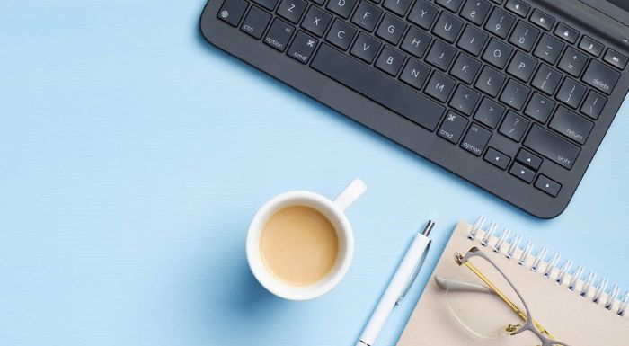 Typewriter, pen, notepad and coffee cup