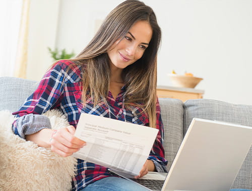 young woman laptop paperwork check shirt personal finance ICAEW students