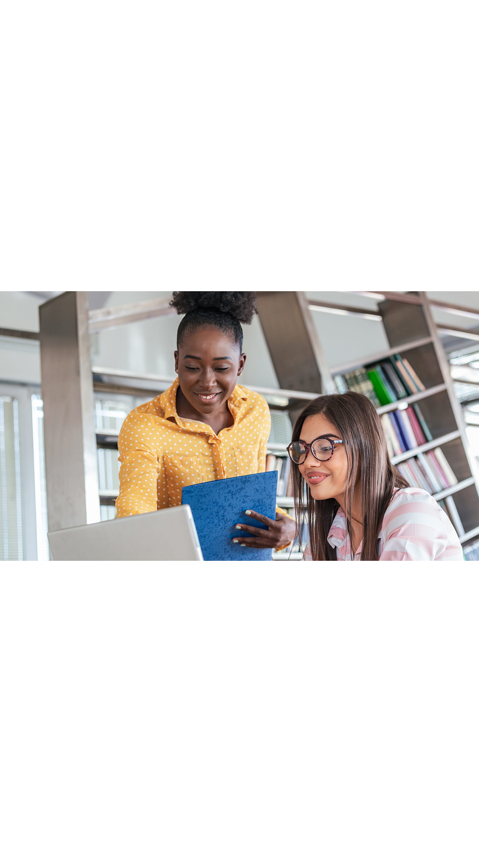 two young women working training laptop office Level 7 assessment ICAEW students accountant