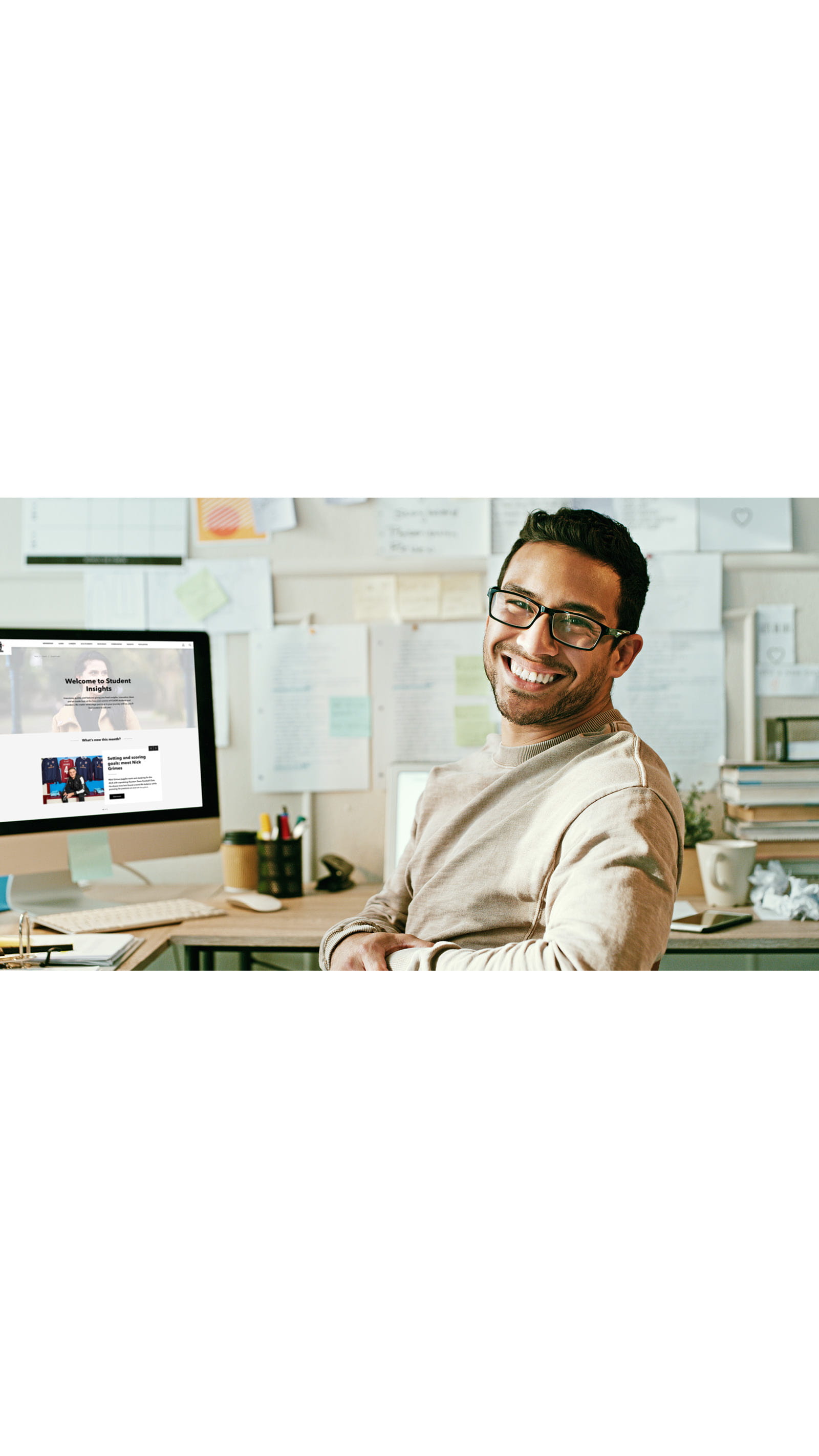 young man glasses office study desk student desktop computer pinboard papers post it notes ICAEW website