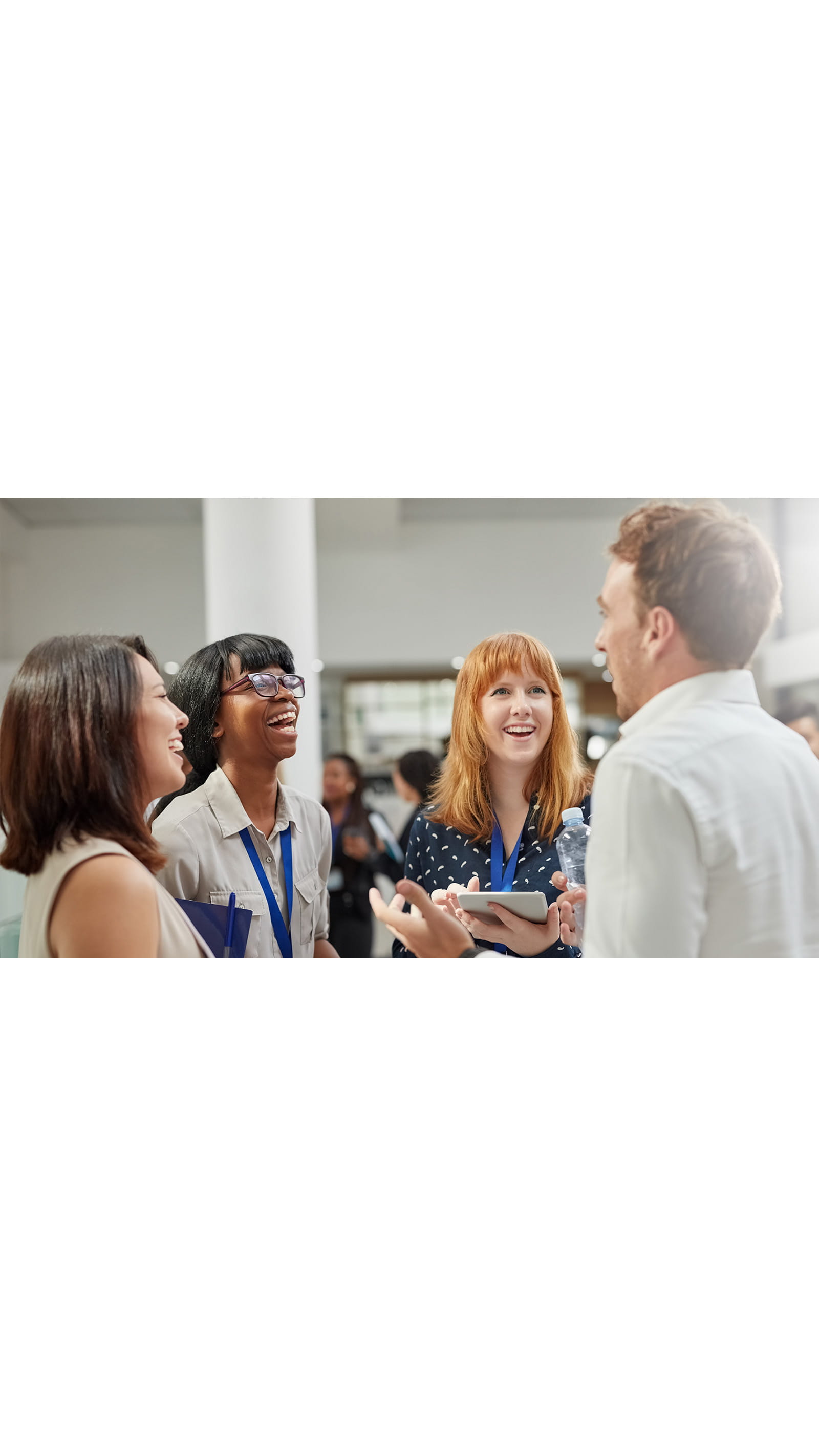 students standing in a group laughing talking lanyards ID London Student Society