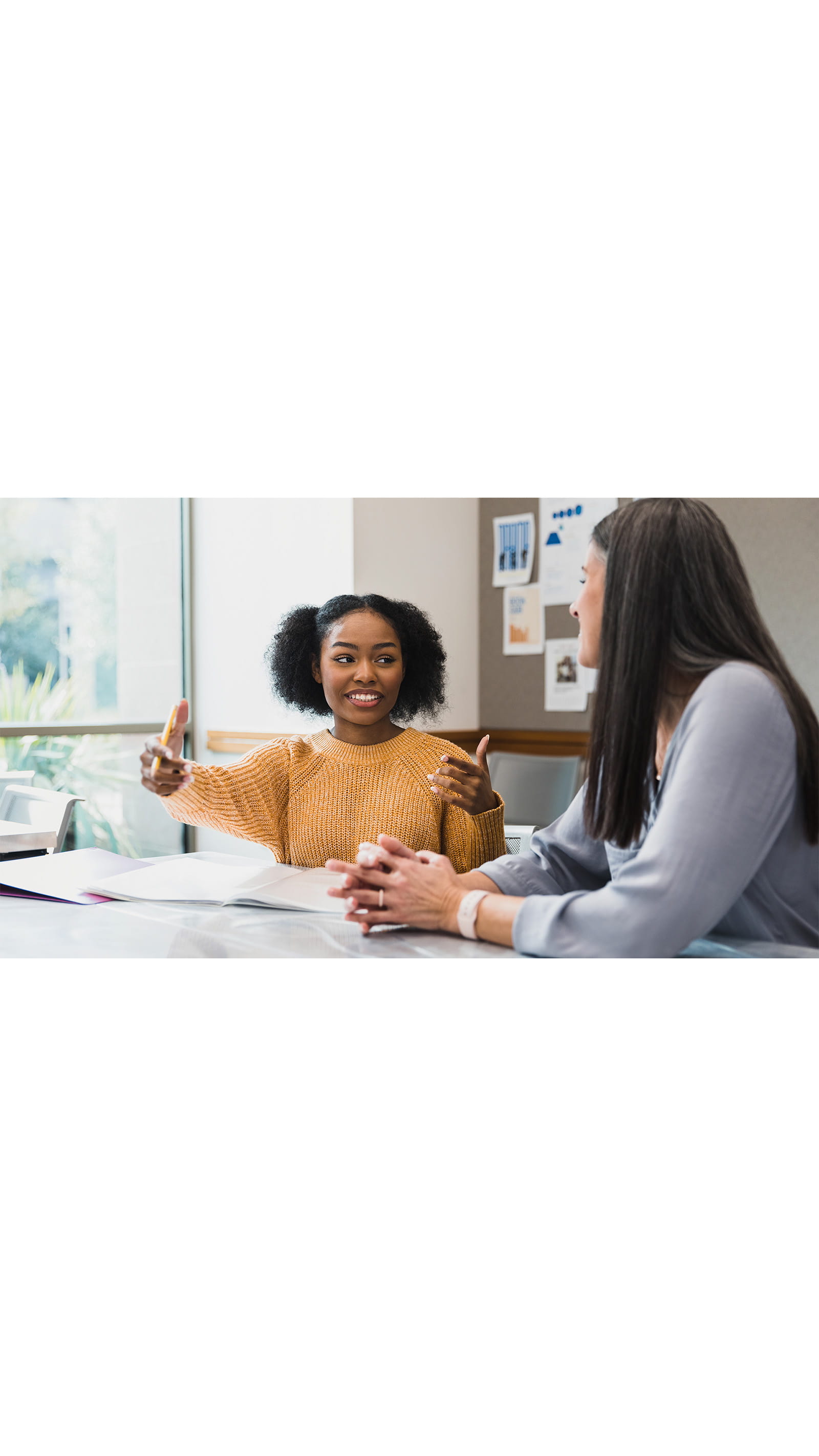 Two young women colleagues office meeting room talking communicating professional language