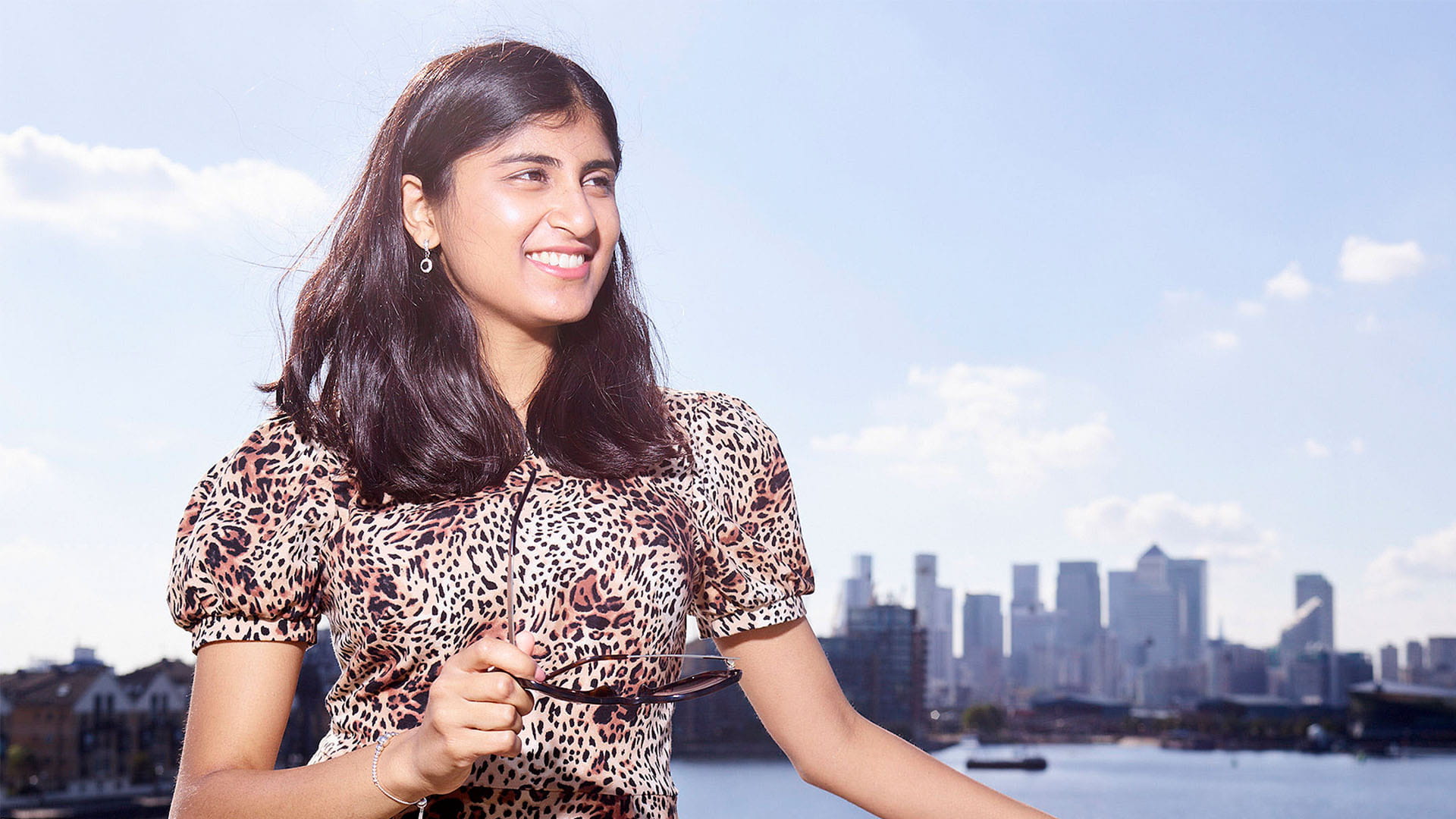 Audit trainee and ACA student Ashwini Poopalasingham standing in front of the Thames river, London city, UK