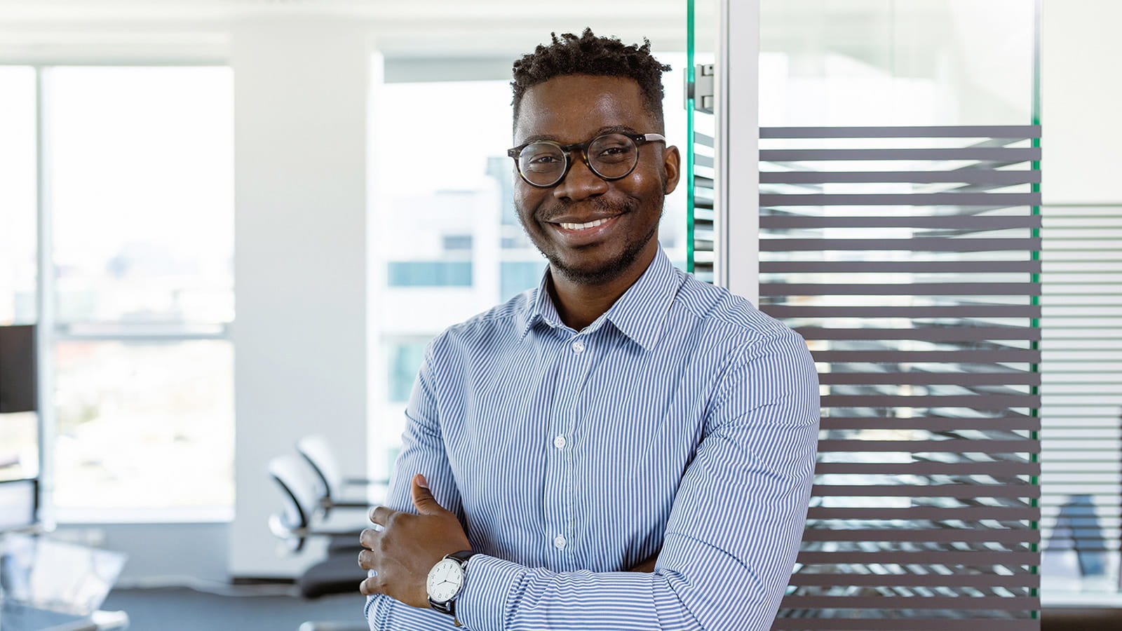 young man wearing glasses smiling blue shirt office employee