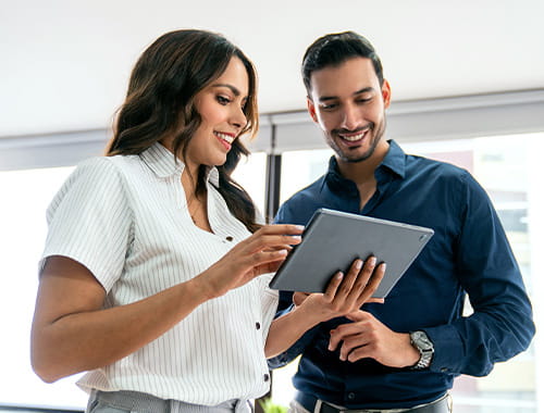 stock photo of two people looking at a tablet smiling