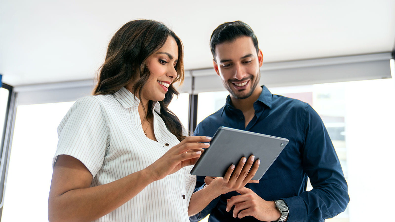 stock photo of two people looking at a tablet smiling