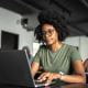 young woman student wearing glasses working on a laptop studying exams