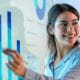 young woman employee smiling working meeting room presenting pointing to a chart table on a digital screen
