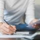 Person working on paperwork with a calculator