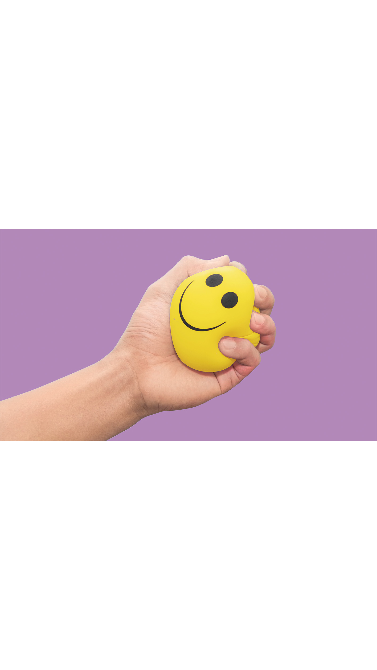 yellow stress ball smiley face held squeezes in a hand purple background