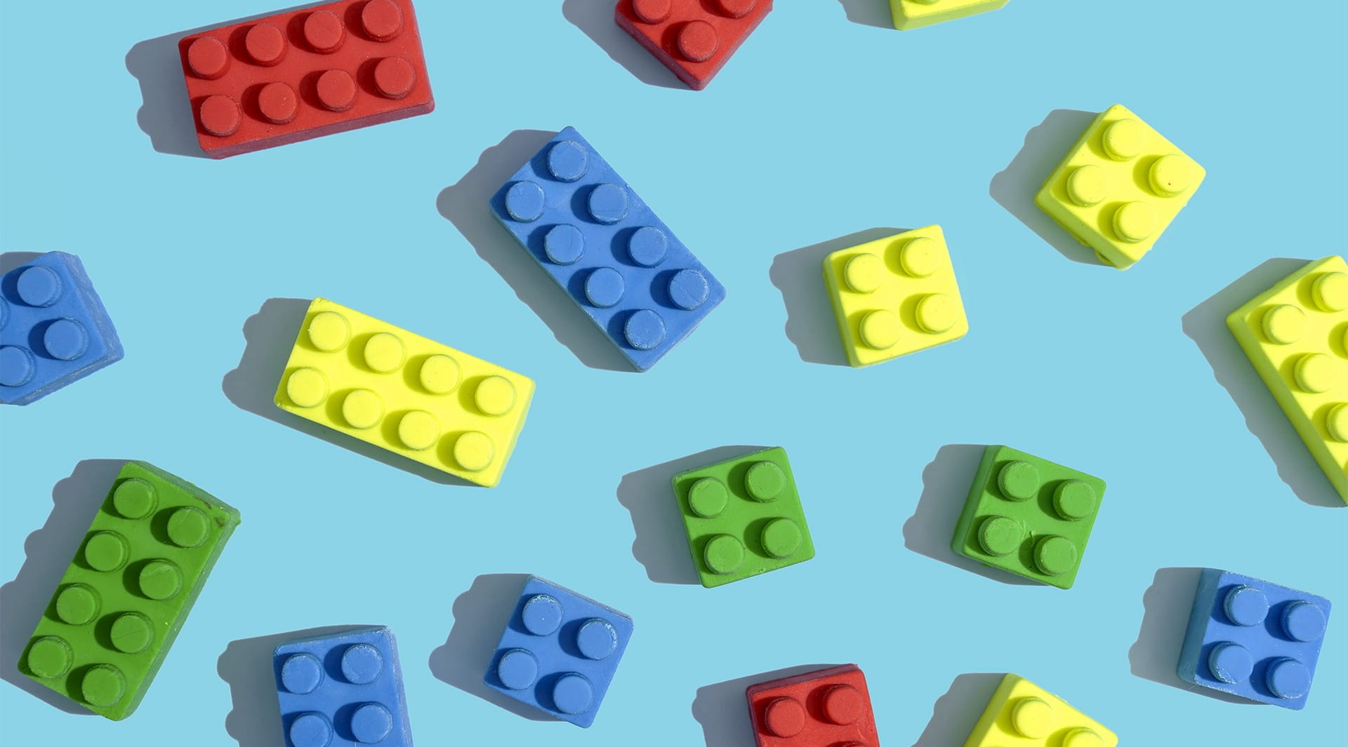 lego pieces building blocks red blue green yellow on a blue background