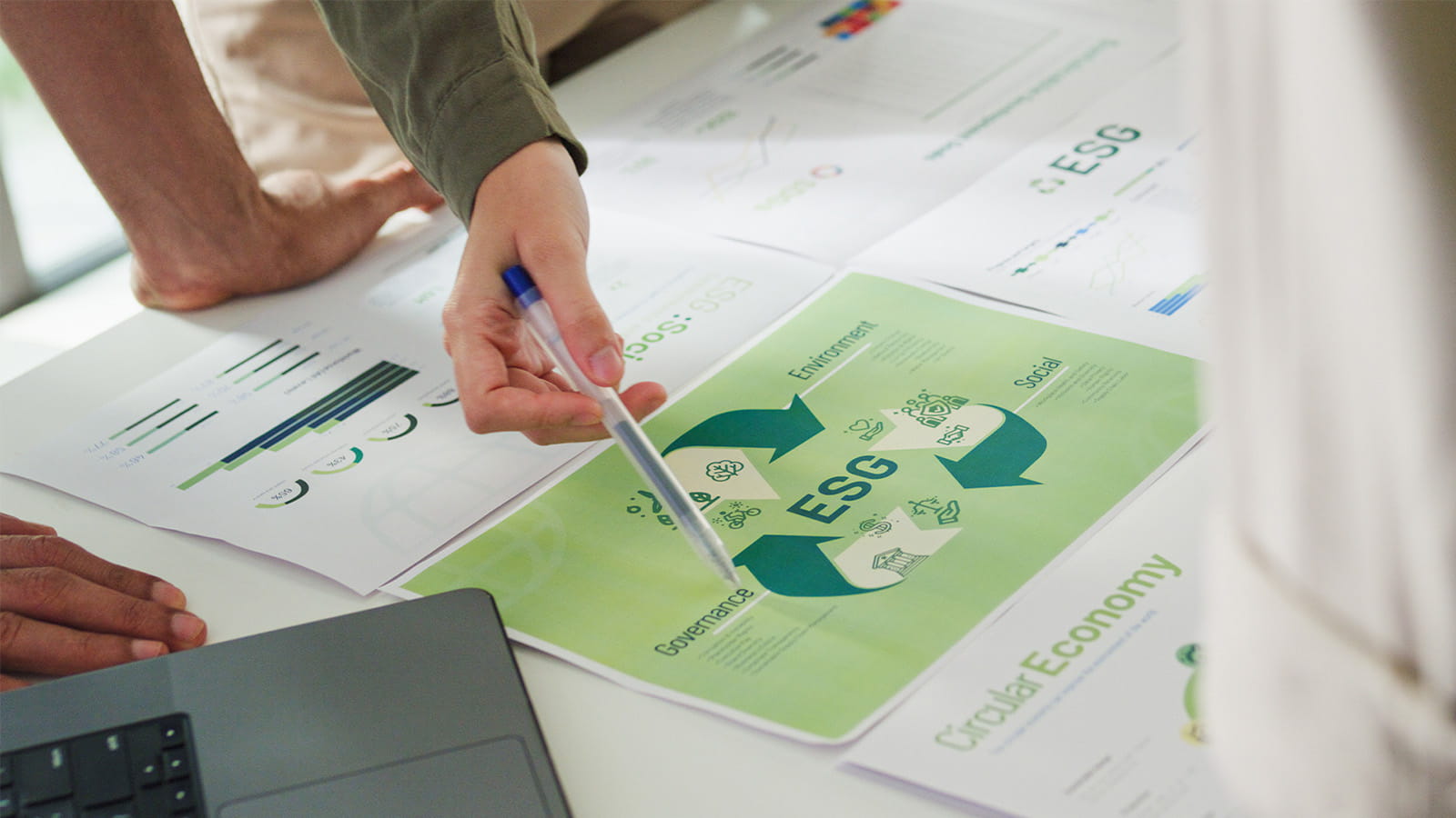 office meeting colleagues pointing at a green ESG triangle arrows flowchart