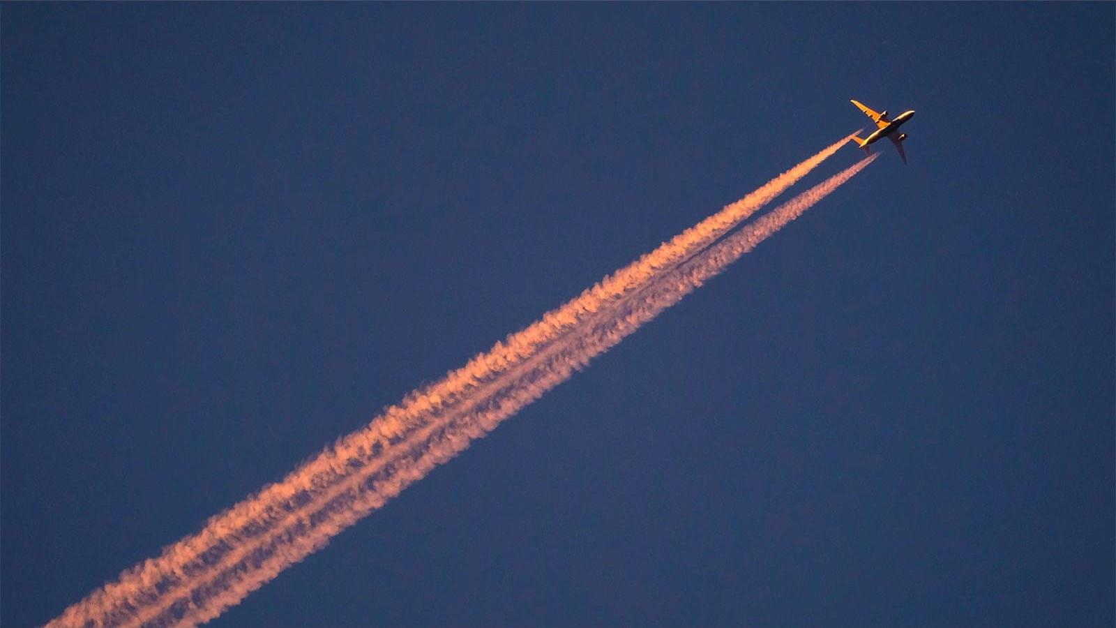 plane dark blue sky jet stream