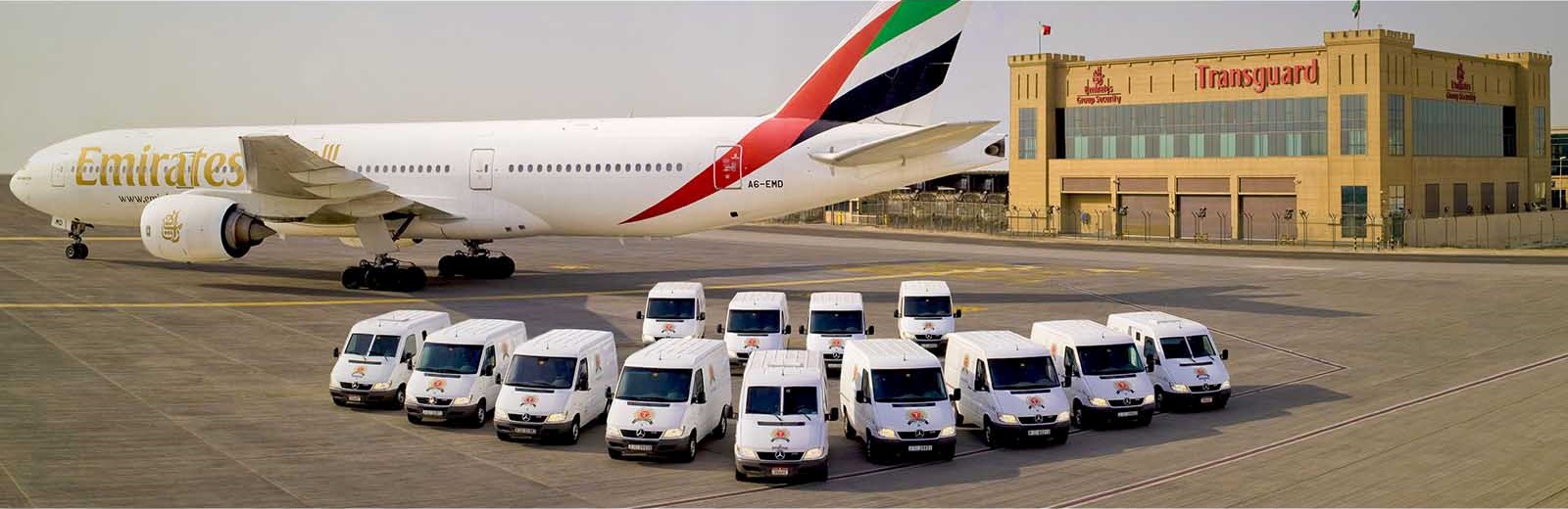 Transguard is spreading its wings in the UAE vans on airport tarmac middle east Emirates plane