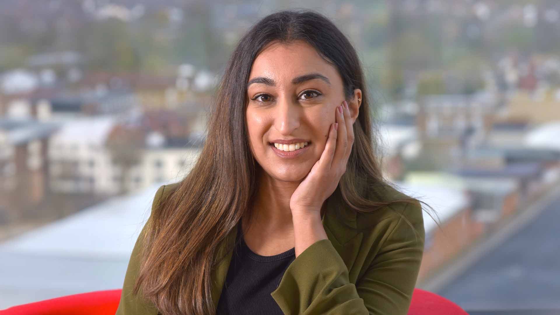 Shivani Kotecha, transaction services manager, BDO. Young asian woman head resting in hand city in background