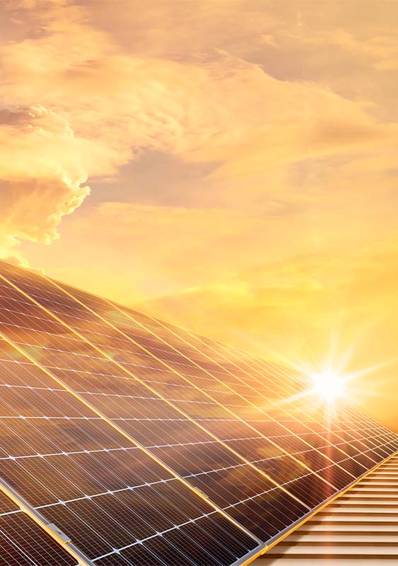 setting sun sunset shining reflecting on a row of solar panels orange glow clouds