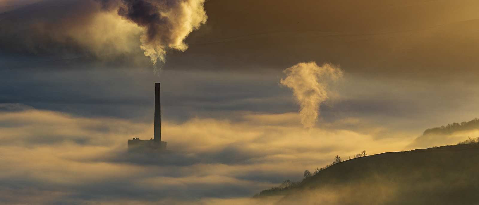 Hope valley and Castleton on a stunning misty morning with the pollution of the local cement factory.  Peak District National park. Derbyshire.
