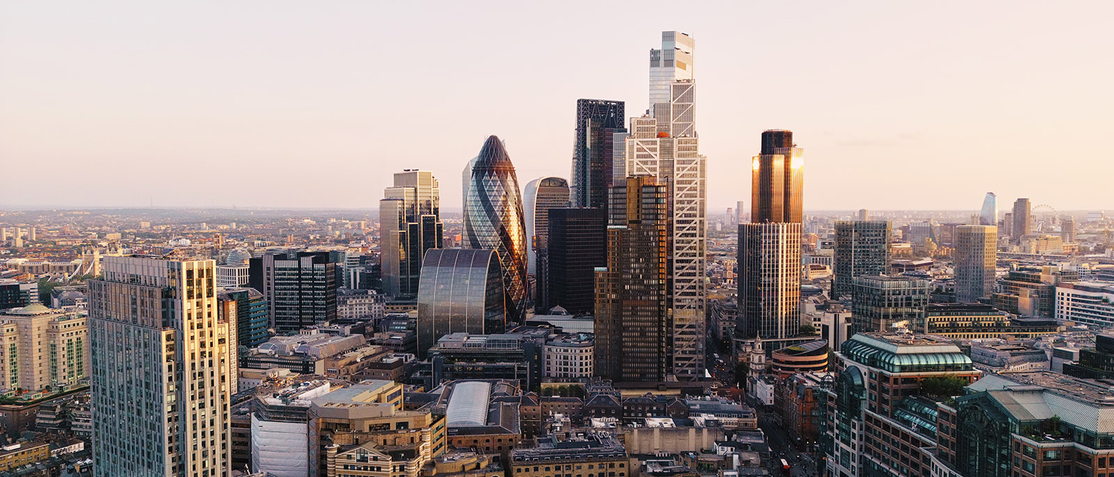 City of London skyline United Kingdom sunset pink orange sky sun reflecting on skyscraper buildings glass windows