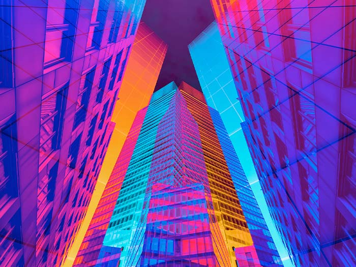 digital collage image looking up at city skyscraper buildings colourful purple prink blue orange