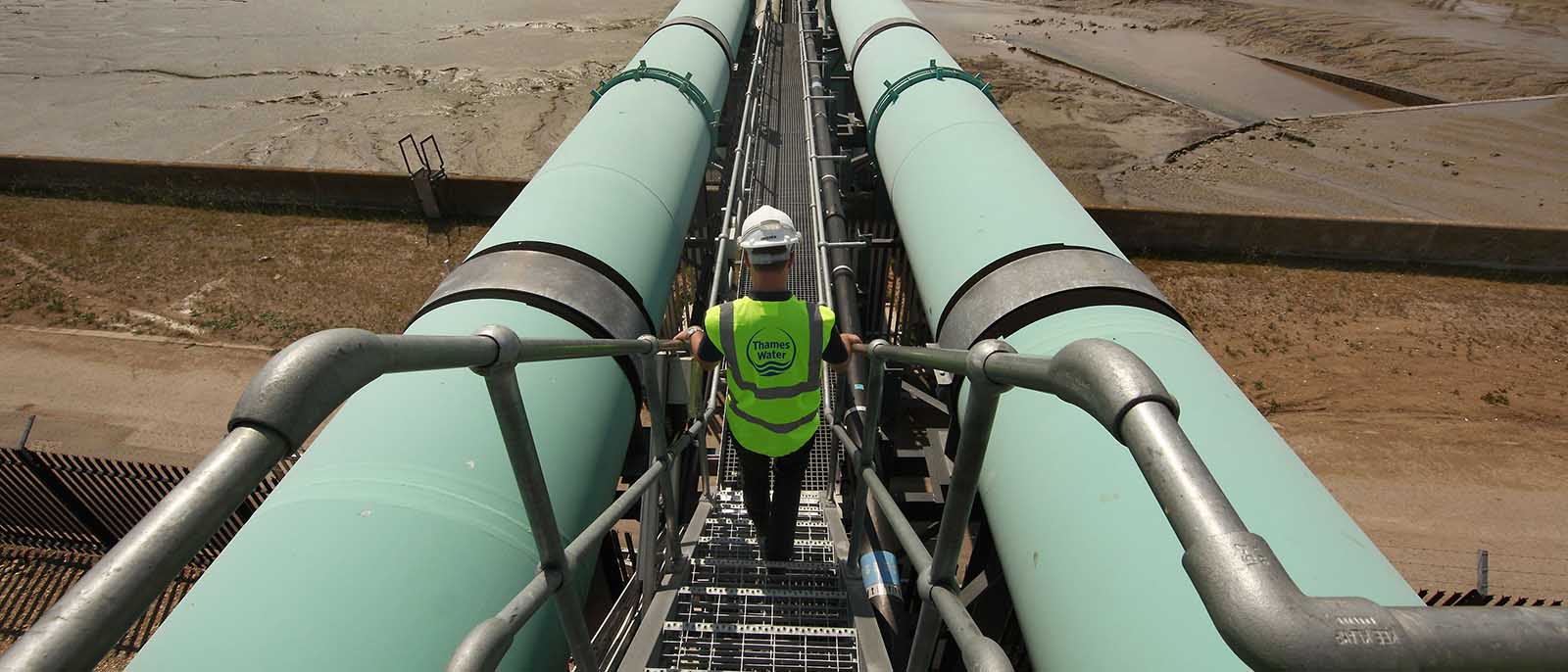 worker engineer high-vis hard hat walking stairs mainland de-salination plant, which is known as the Thames Gateway Water Treatment Works
