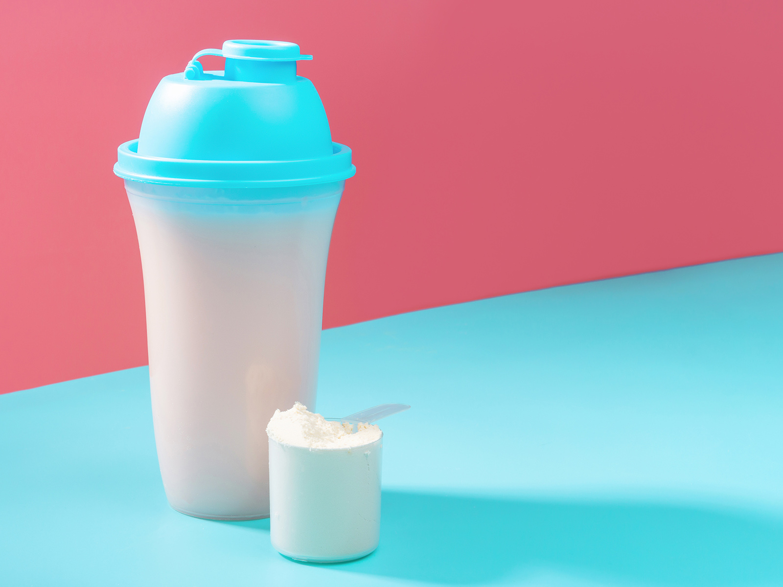 photo of a protein powder scoop shake bottle blue pink
