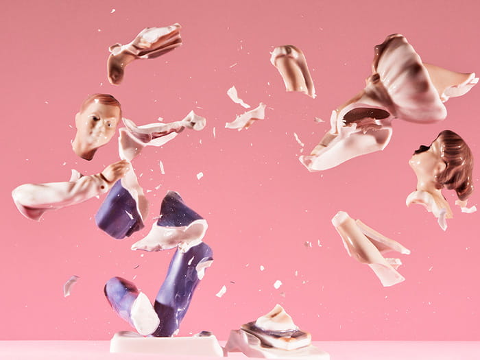 china porcelain statue breaking smashing into tiny pieces pink background