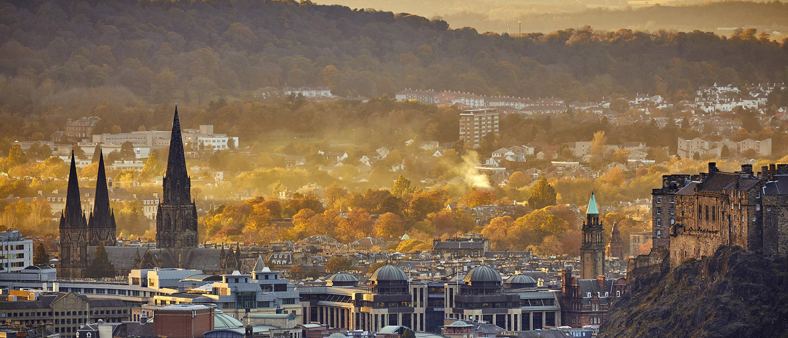 Edinburgh Scotland city hazy golden hour autumn buildings church castle hills