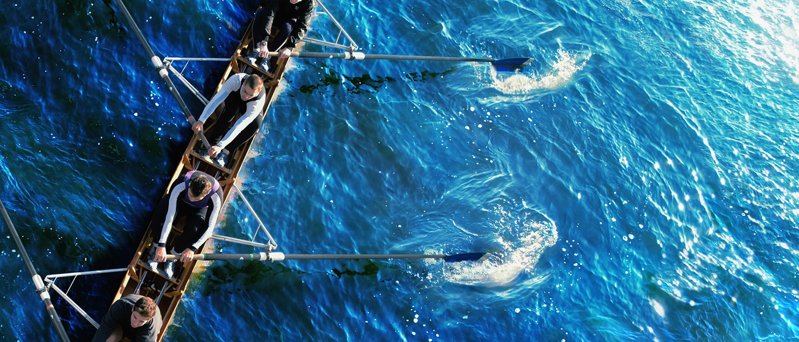 rowing team blue water river sport birds eye aerial view