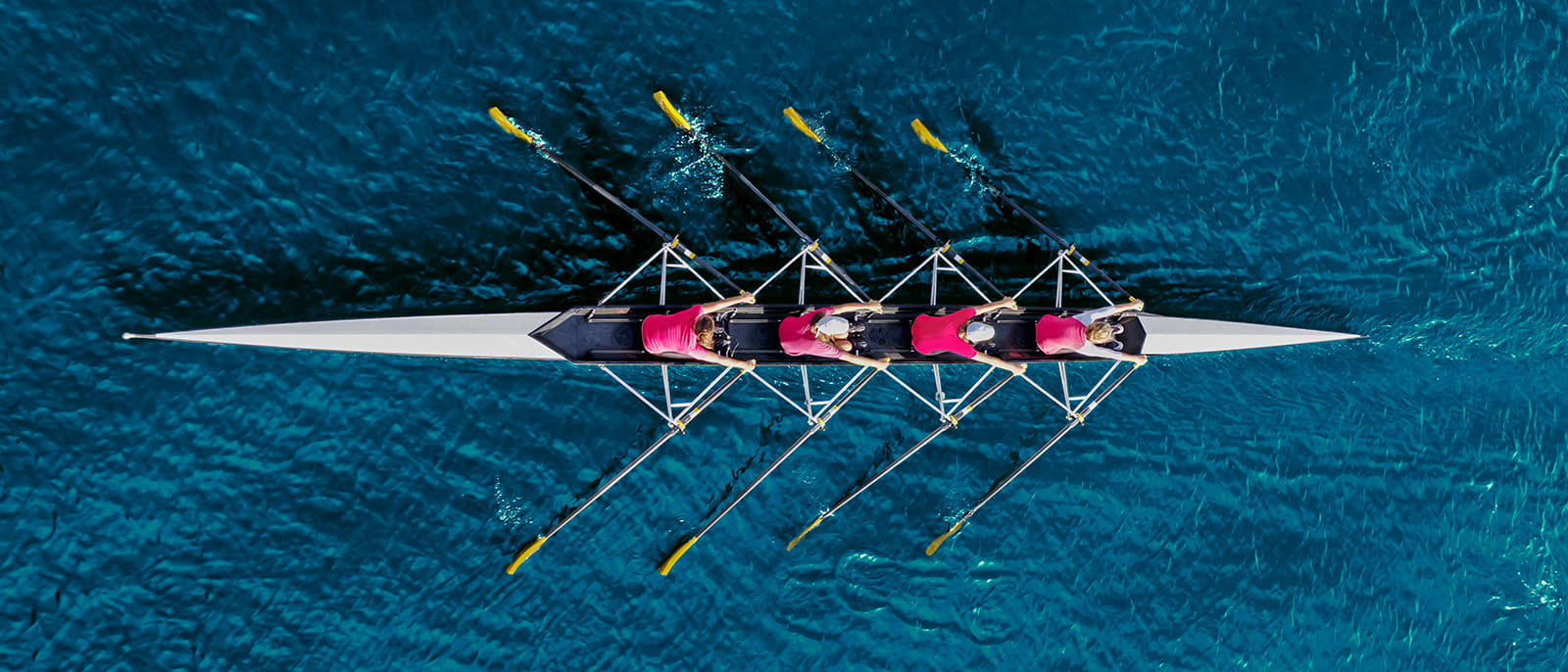 rowing team blue water river sport birds eye aerial view