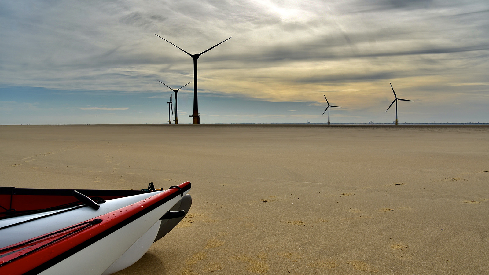 On Scroby Sands beach, near Great Yarmouth, Norfolk UK, kayaks wind turbines