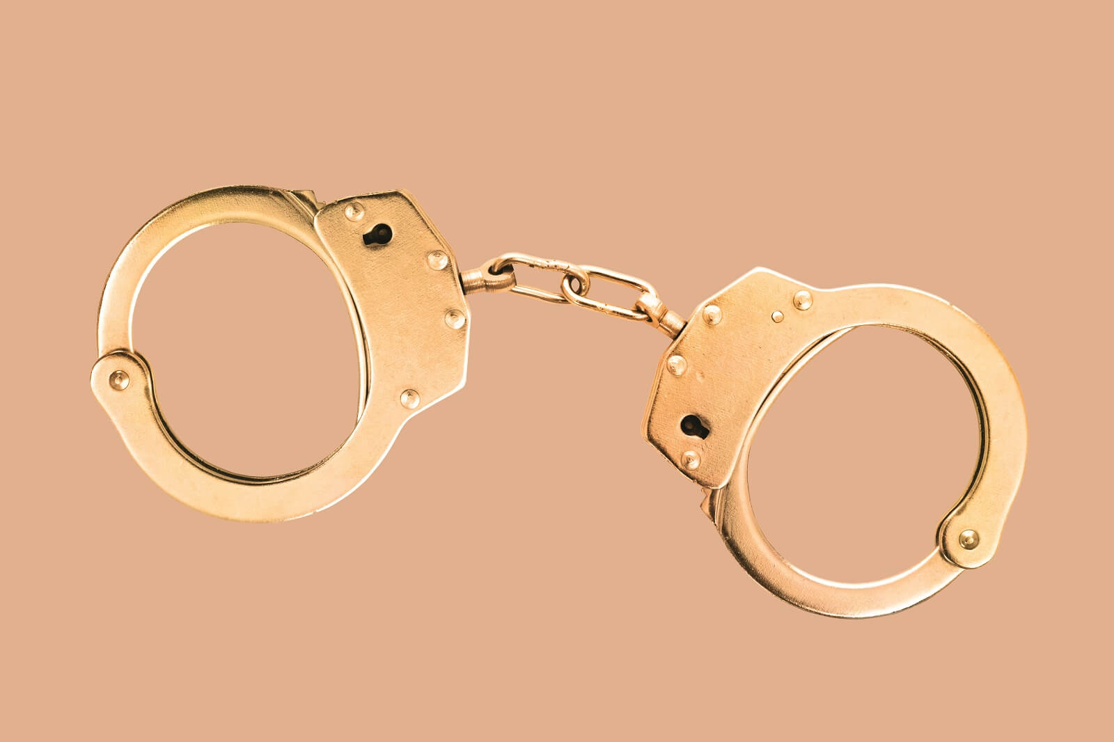 Handcuffs on orange background