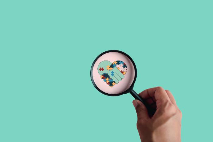 Magnify glass pointed at puzzle piece heart