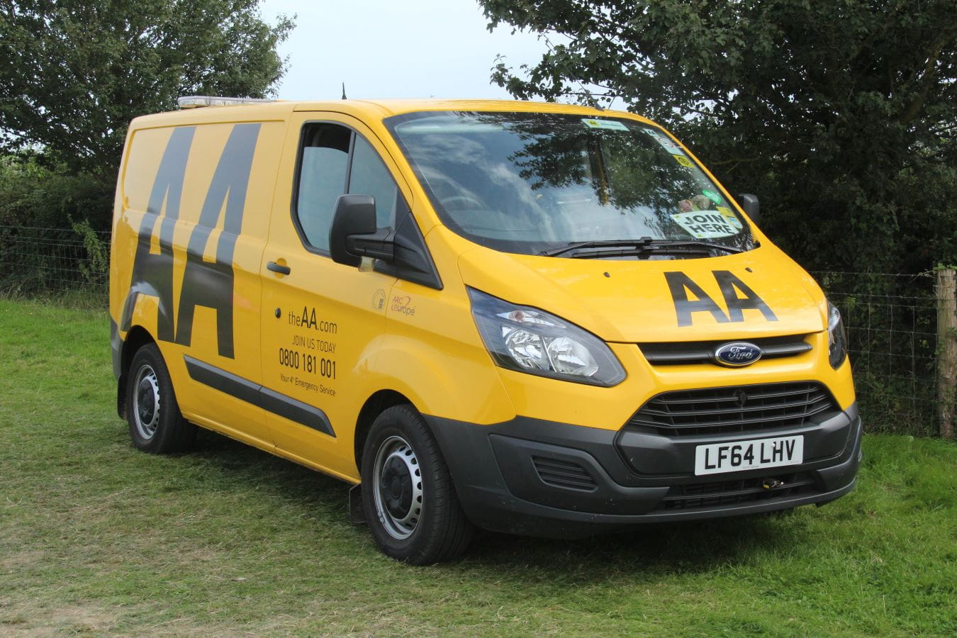 Yellow AA van parked on the grass