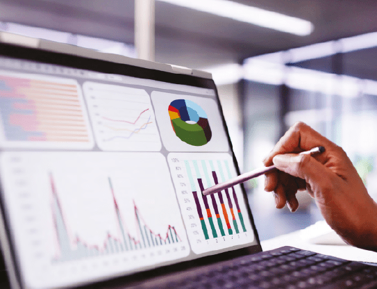 Hand pointing at data on laptop screen