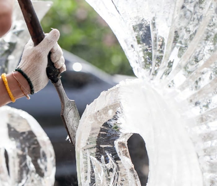 Person carving an ice sculpture