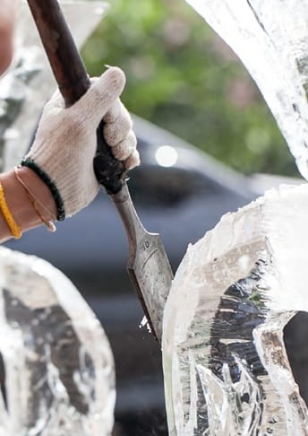 Person carving an ice sculpture