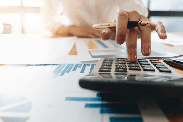 Close up of a hand pressing calculator buttons